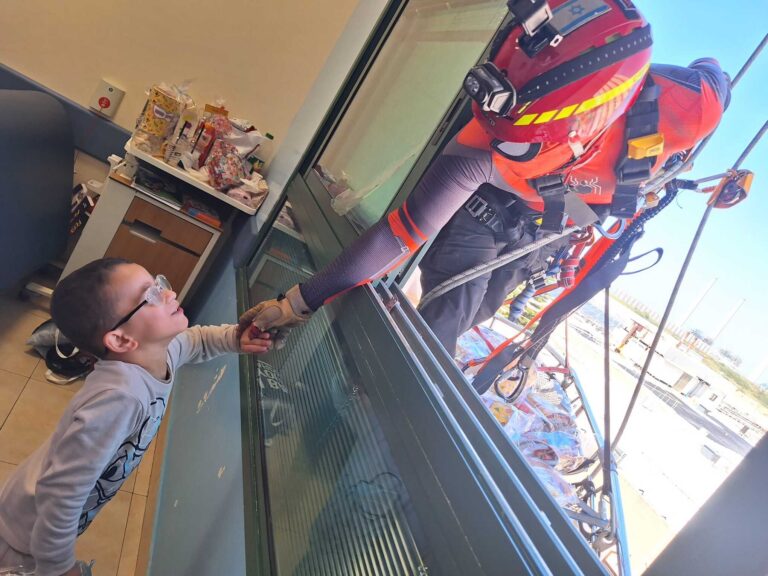 Superheroes hand out mishloach manot through the window